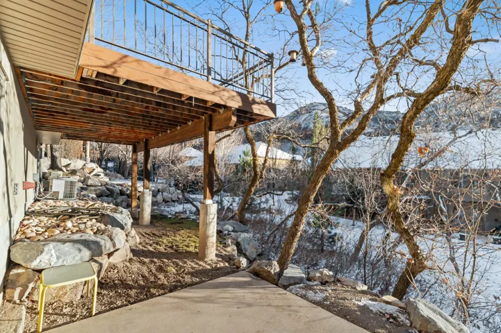 Snow covered patio with a deck with mountain view