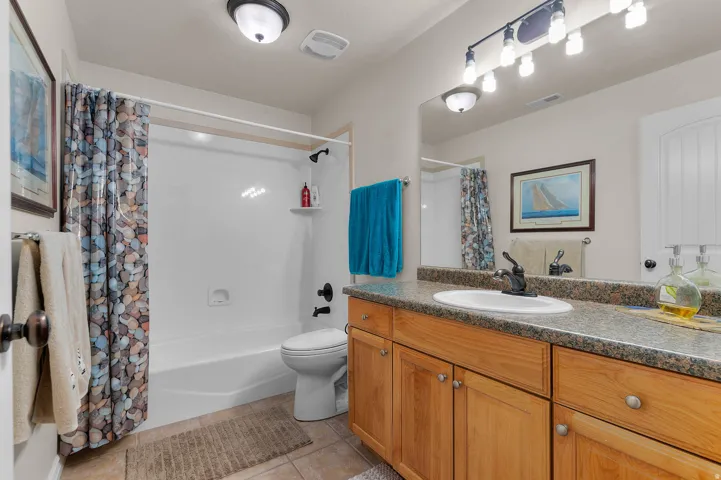 Bathroom with vanity, shower / tub combo with curtain, and light tile patterned floors
