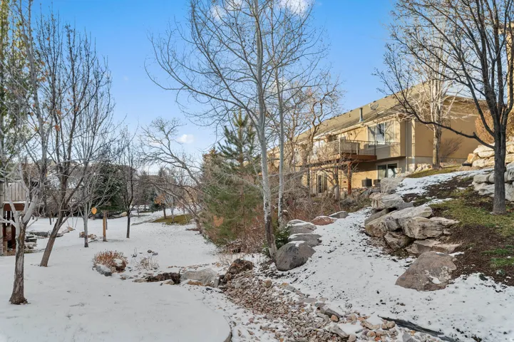 Snowy yard featuring a balcony