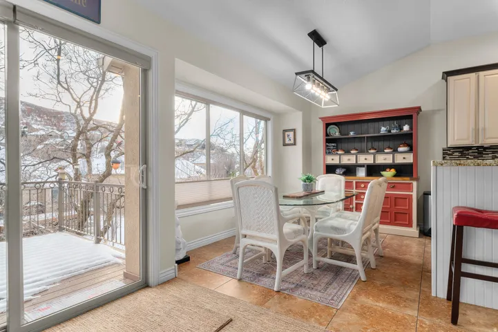 Dining area featuring lofted ceiling and light tile patterned flooring