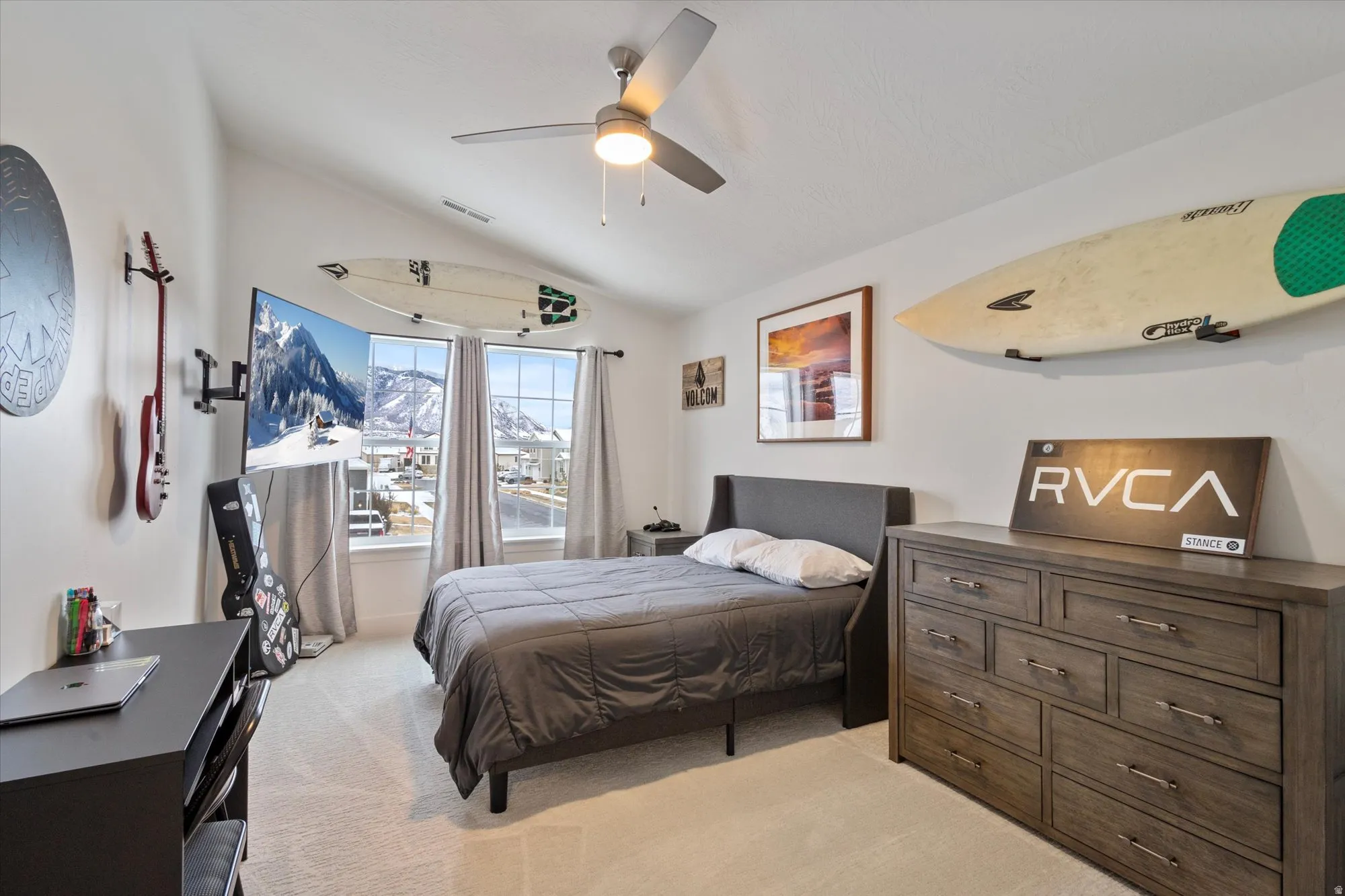 Bedroom with vaulted ceiling, light colored carpet, and ceiling fan