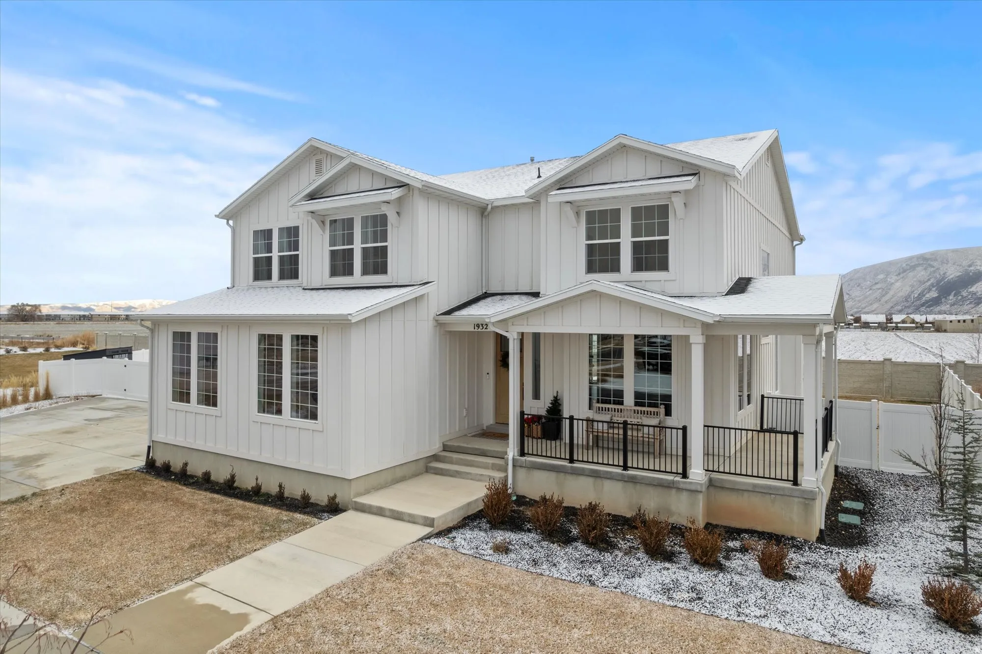 Modern farmhouse featuring a porch, board and batten siding, and concrete driveway