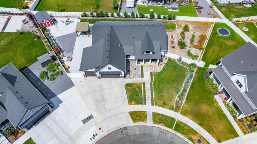 Expansive concrete driveway, attached two-car garage, covered entry porch, and mature landscaping