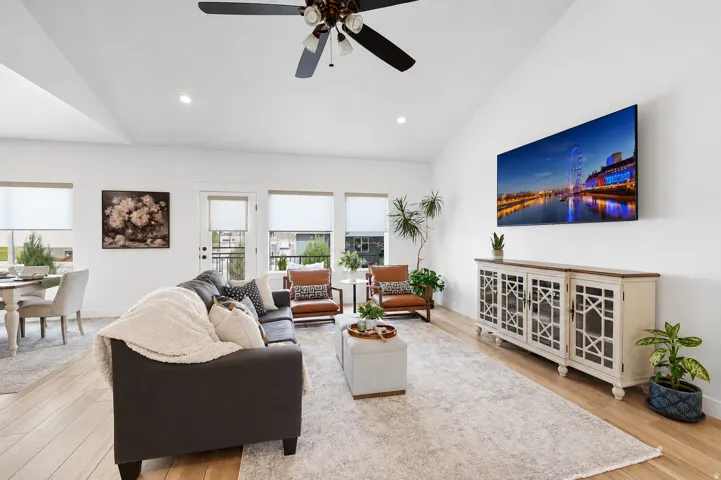 Vaulted ceilings, recessed lighting, wood-finish flooring, ceiling fan, and multiple windows