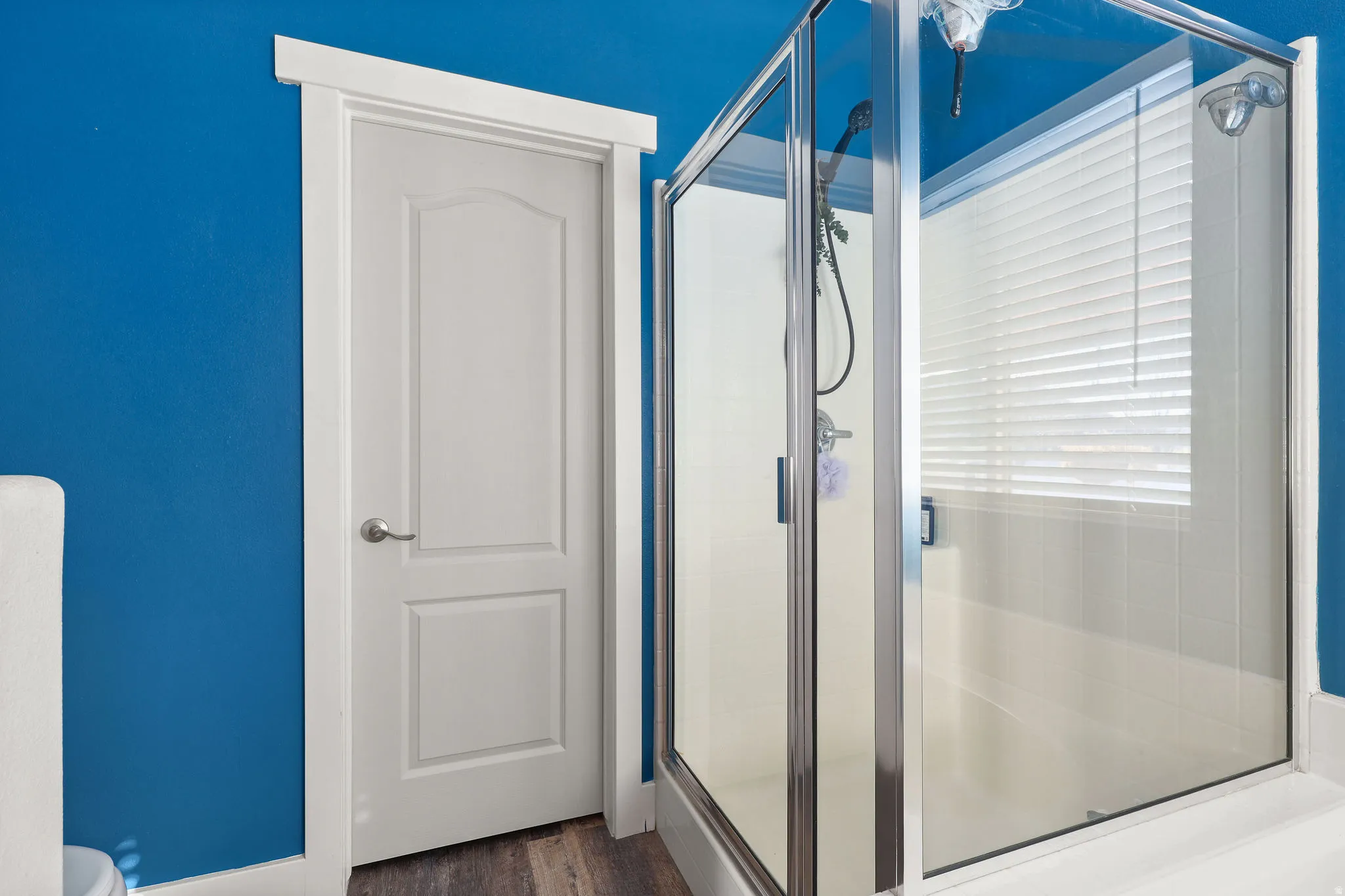 Bathroom featuring a stall shower and dark wood-style flooring