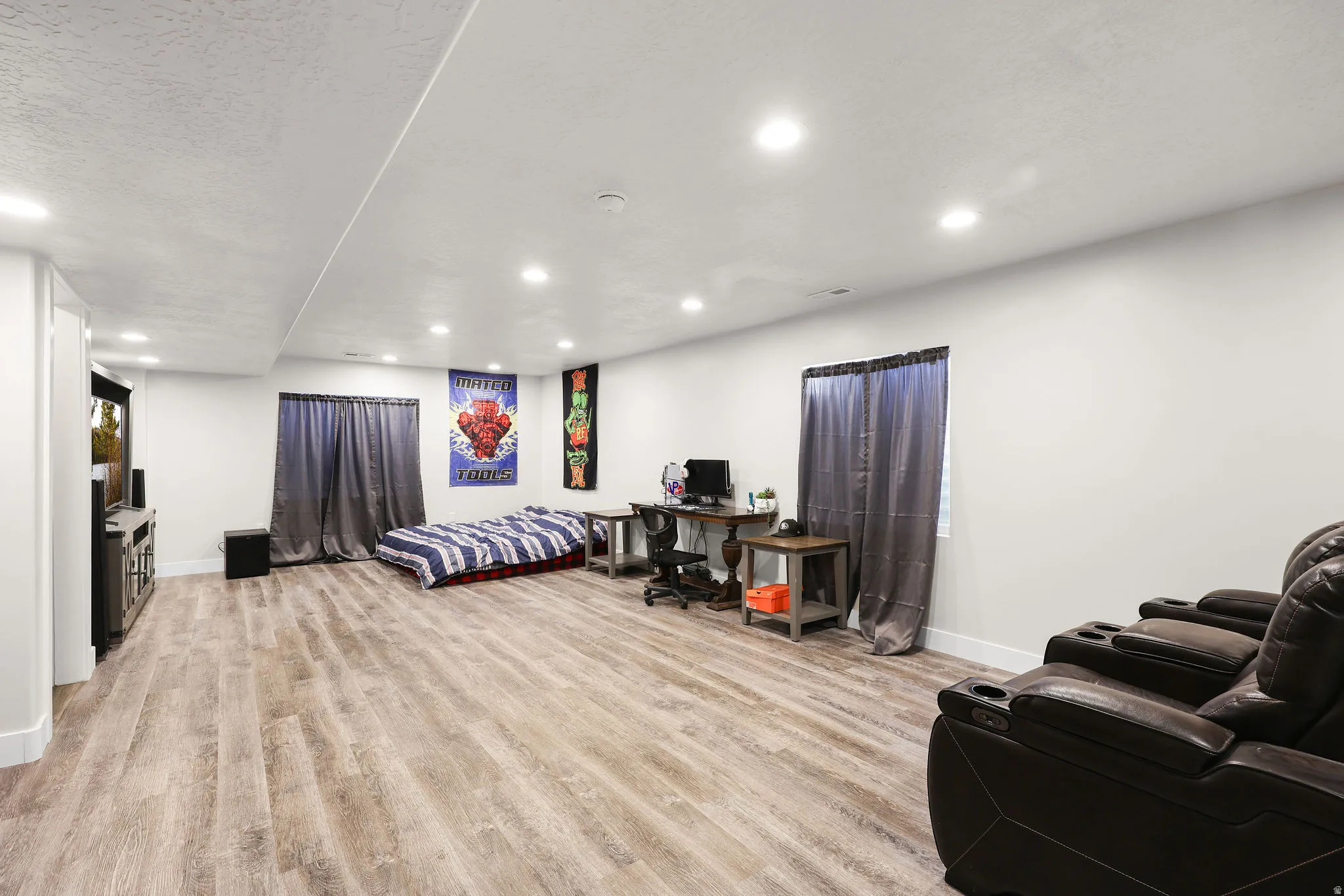 Bedroom with recessed lighting, light wood-style flooring, and a textured ceiling