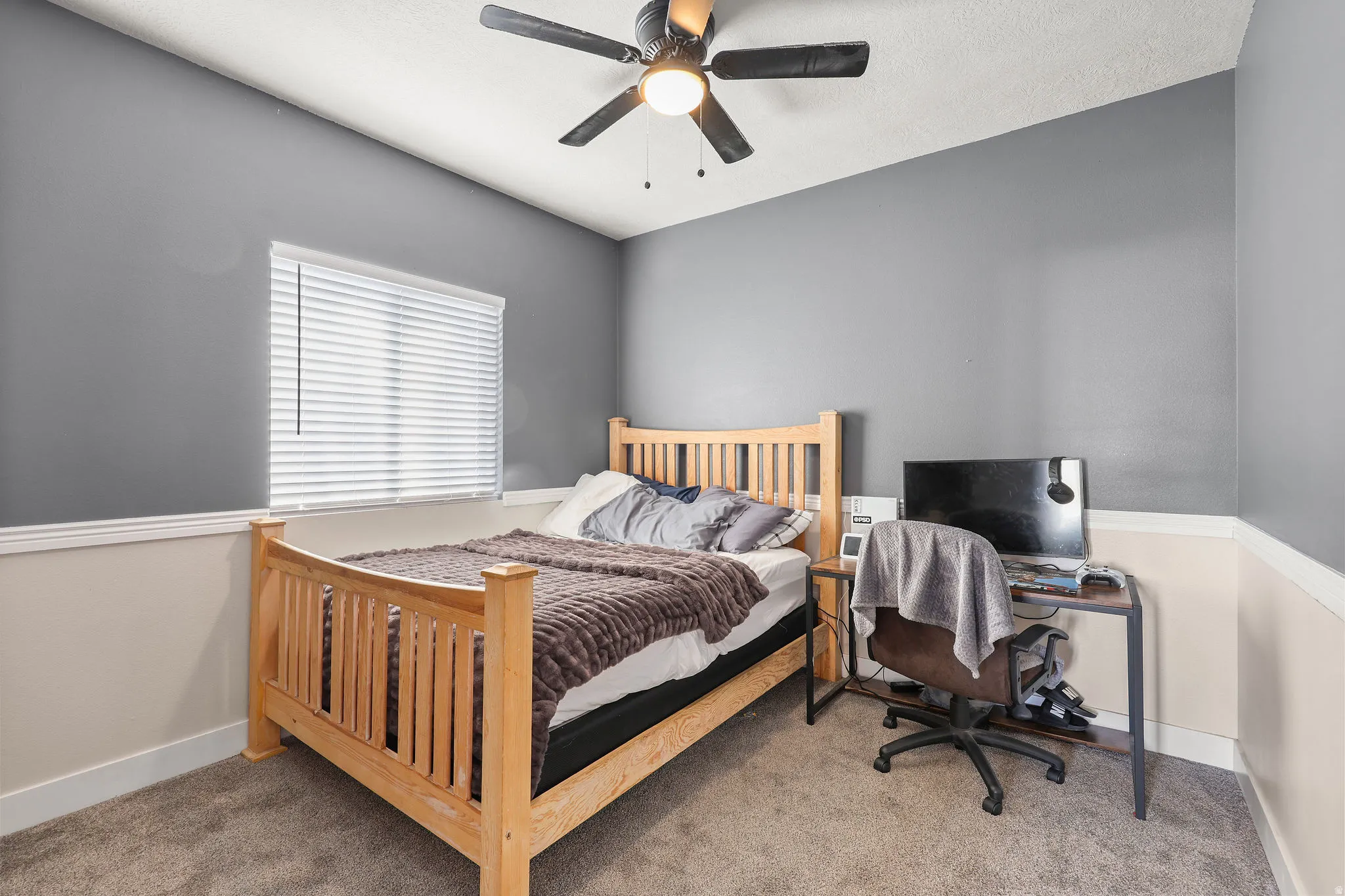 Carpeted bedroom with baseboards and a ceiling fan