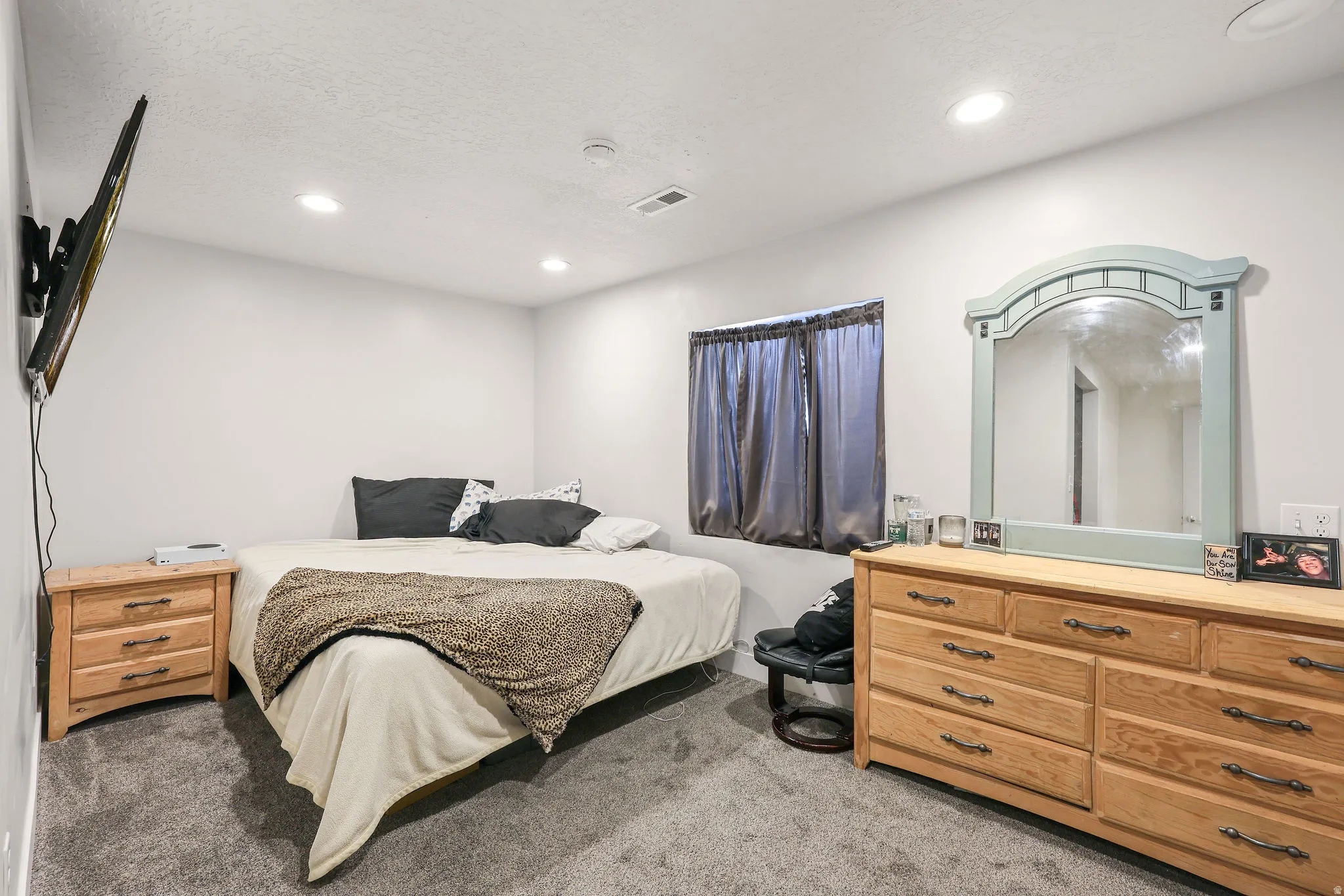 Bedroom with light carpet, recessed lighting, and a textured ceiling