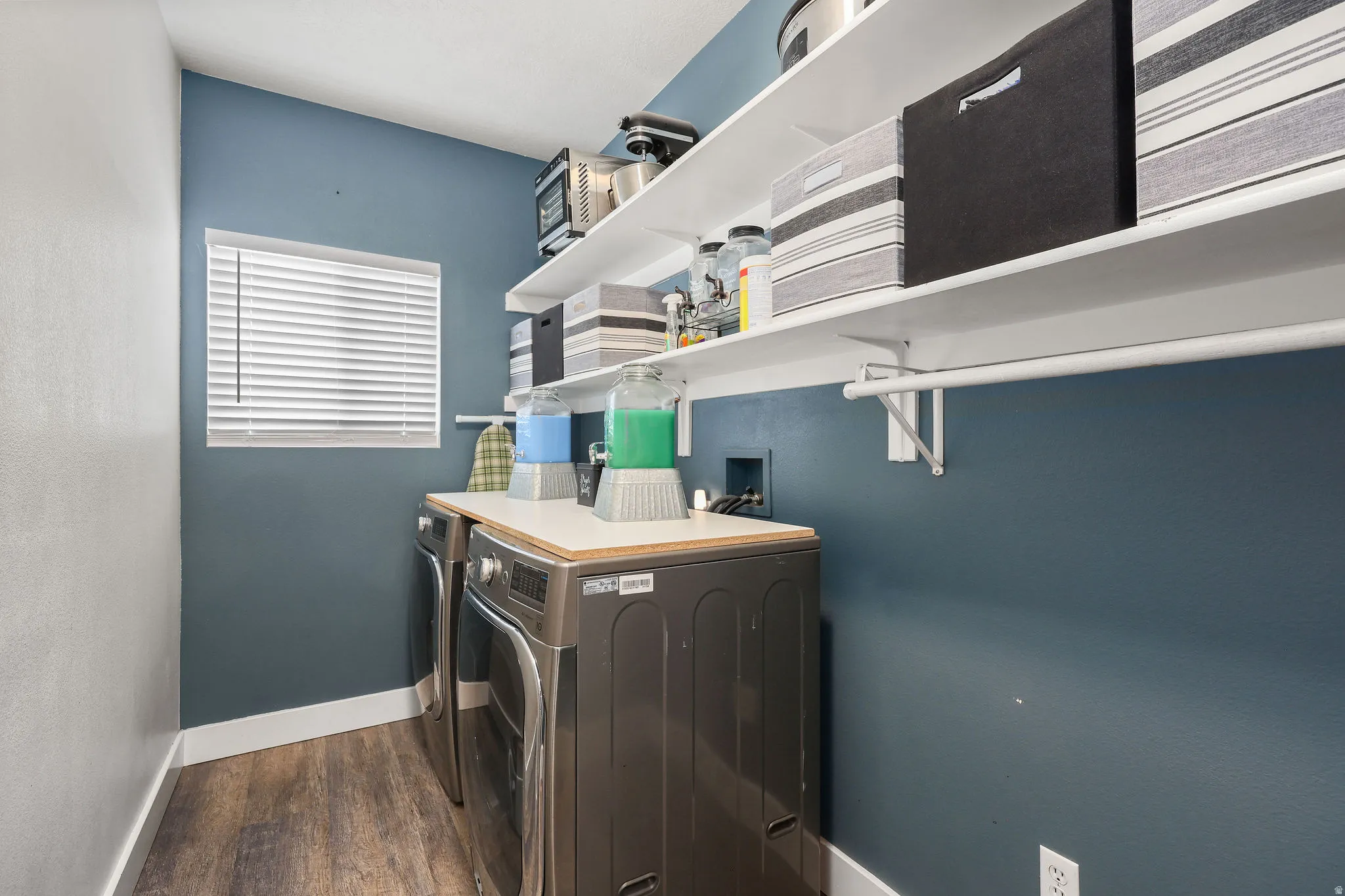 Laundry room with dark wood-style flooring and separate washer and dryer