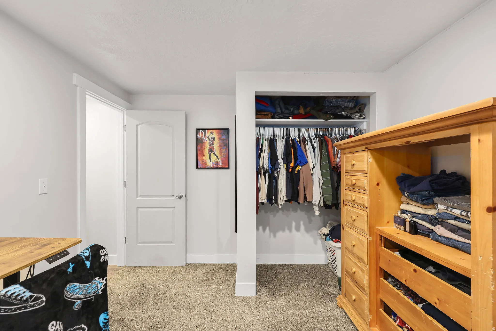 Bedroom with light colored carpet and a closet