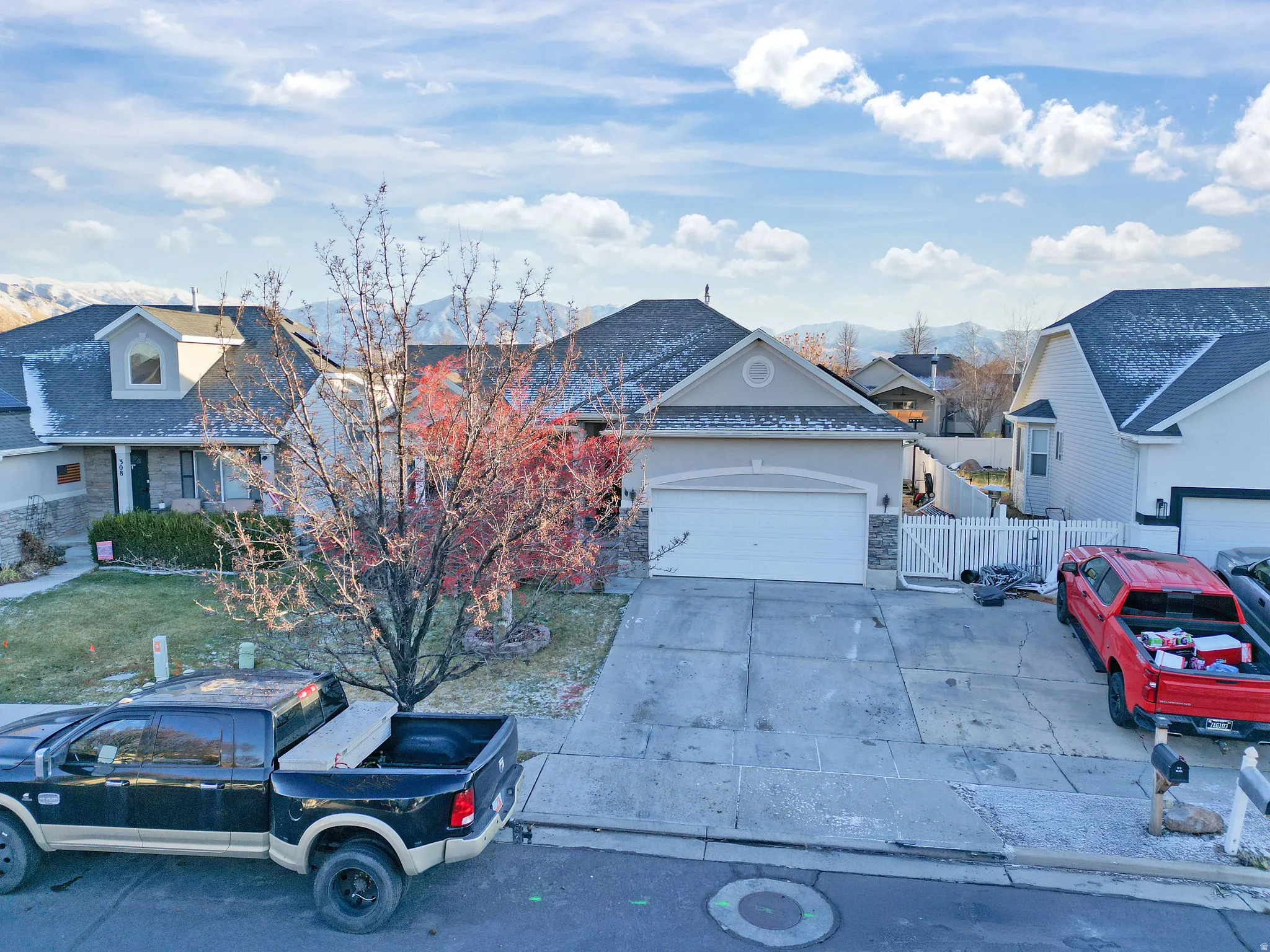 View of front of home featuring concrete driveway, a garage, a residential view, and stucco siding