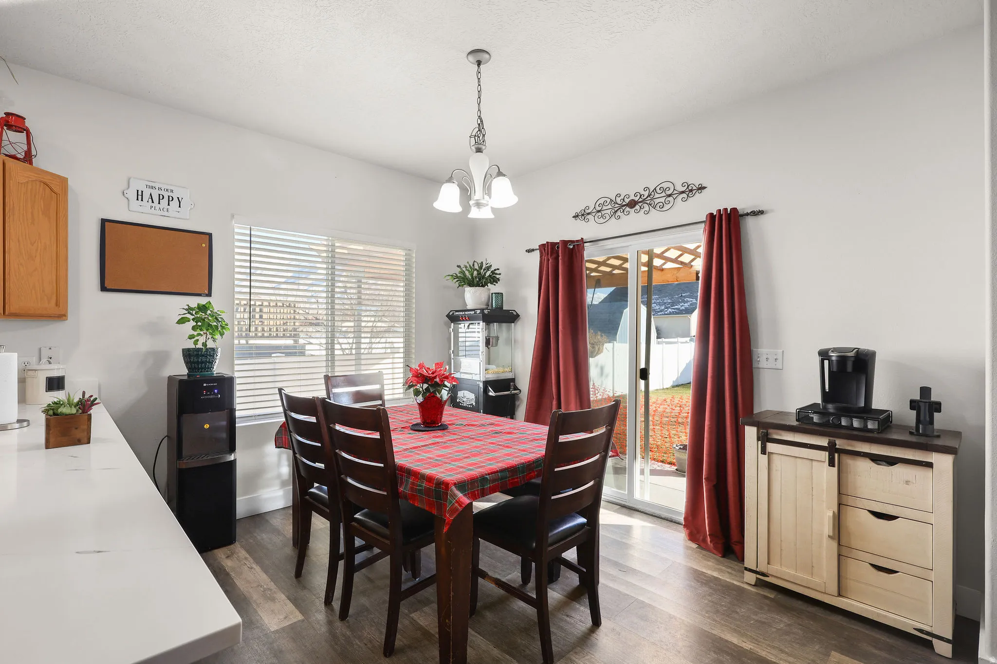Dining area with plenty of natural light, dark wood-style floors, and a chandelier