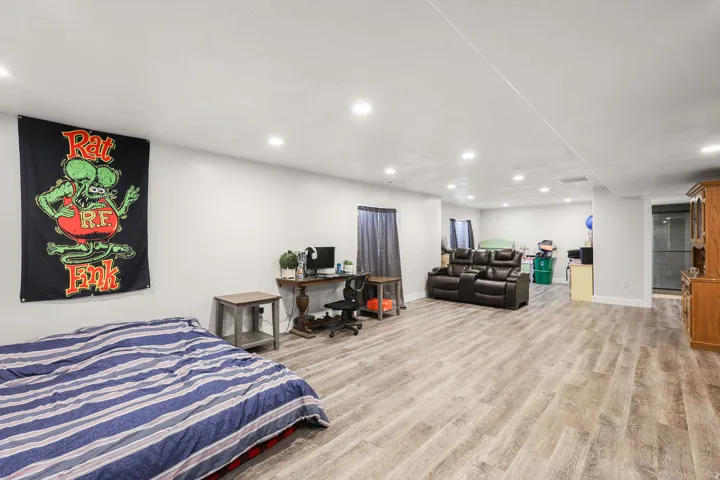 Bedroom with light wood-type flooring, recessed lighting, and a desk