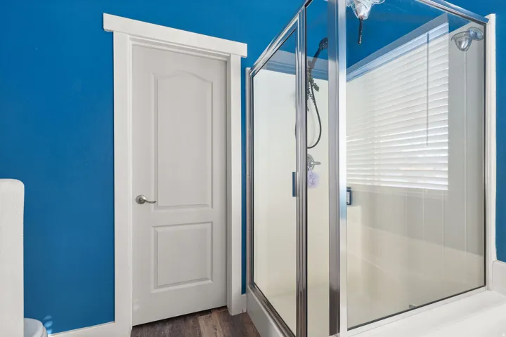 Bathroom featuring a stall shower and dark wood-style flooring