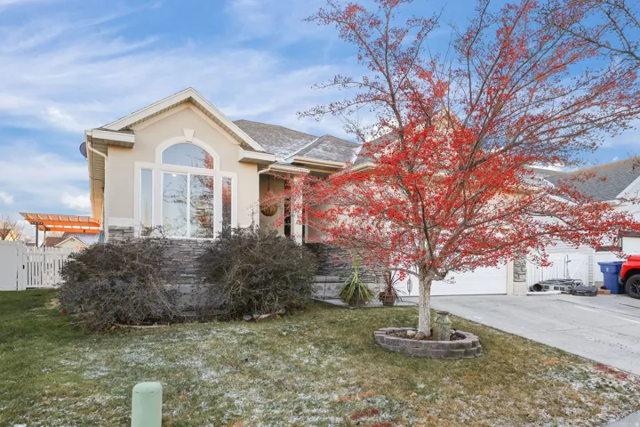 View of front of property with driveway, stucco siding, and a shingled roof