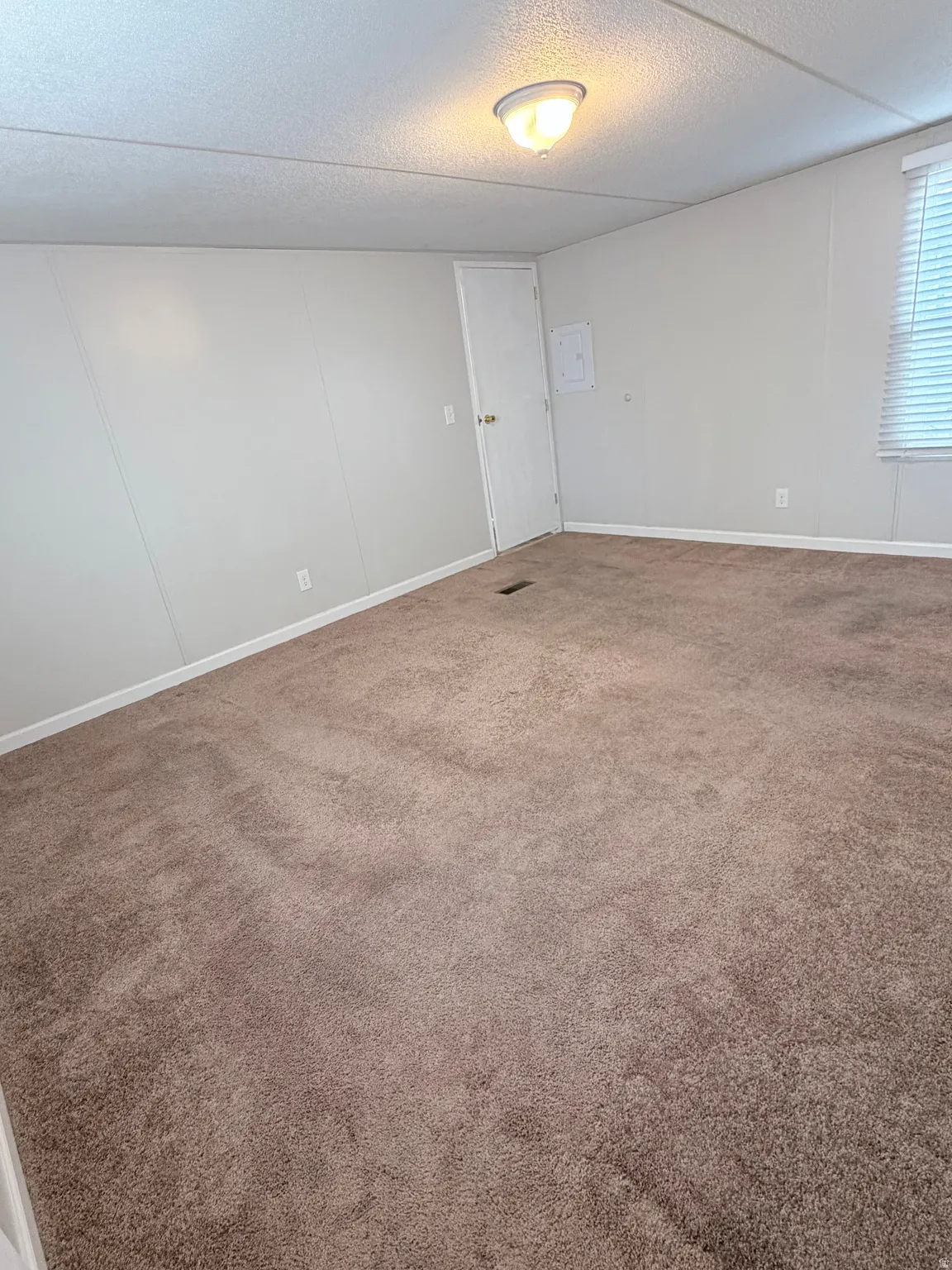 Carpeted empty room featuring a textured ceiling