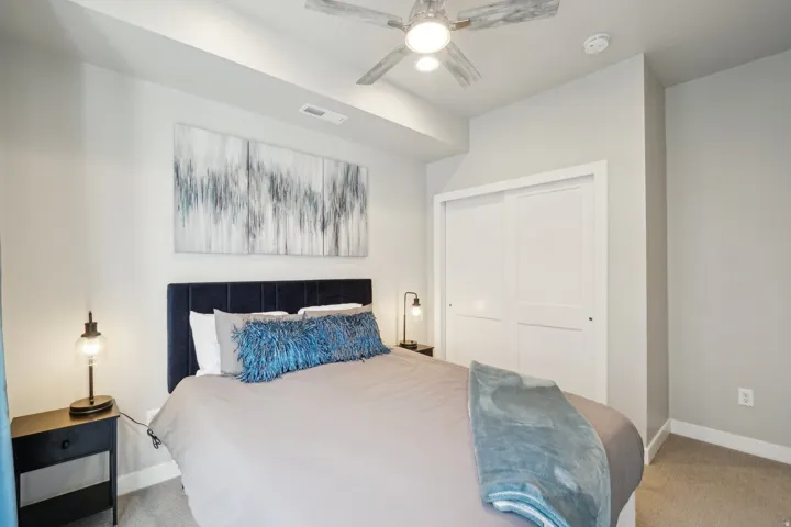 Bedroom featuring light colored carpet, a closet, and a ceiling fan