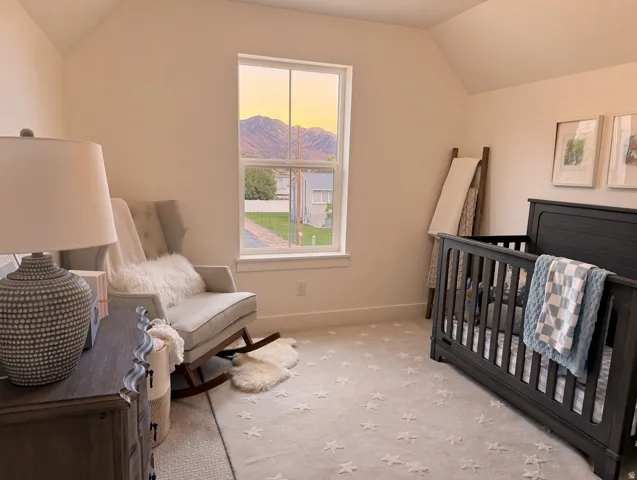 Vaulted ceiling, bright window, and neutral wall tones