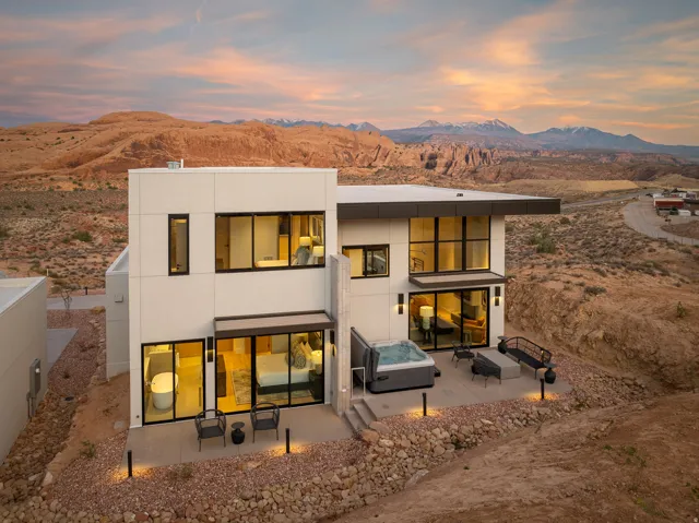 Rear view of property featuring a patio, a mountain view, stucco siding, and a hot tub