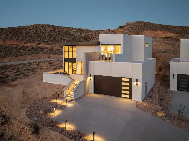Contemporary house featuring stucco siding, concrete driveway, a mountain view, stairs, and an attached garage