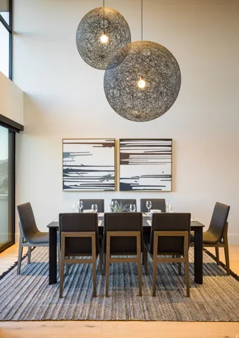 Dining room featuring light wood-type flooring and a towering ceiling
