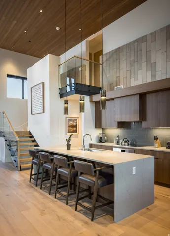 Kitchen with wooden ceiling, modern cabinets, a kitchen bar, light wood-style flooring, and decorative backsplash