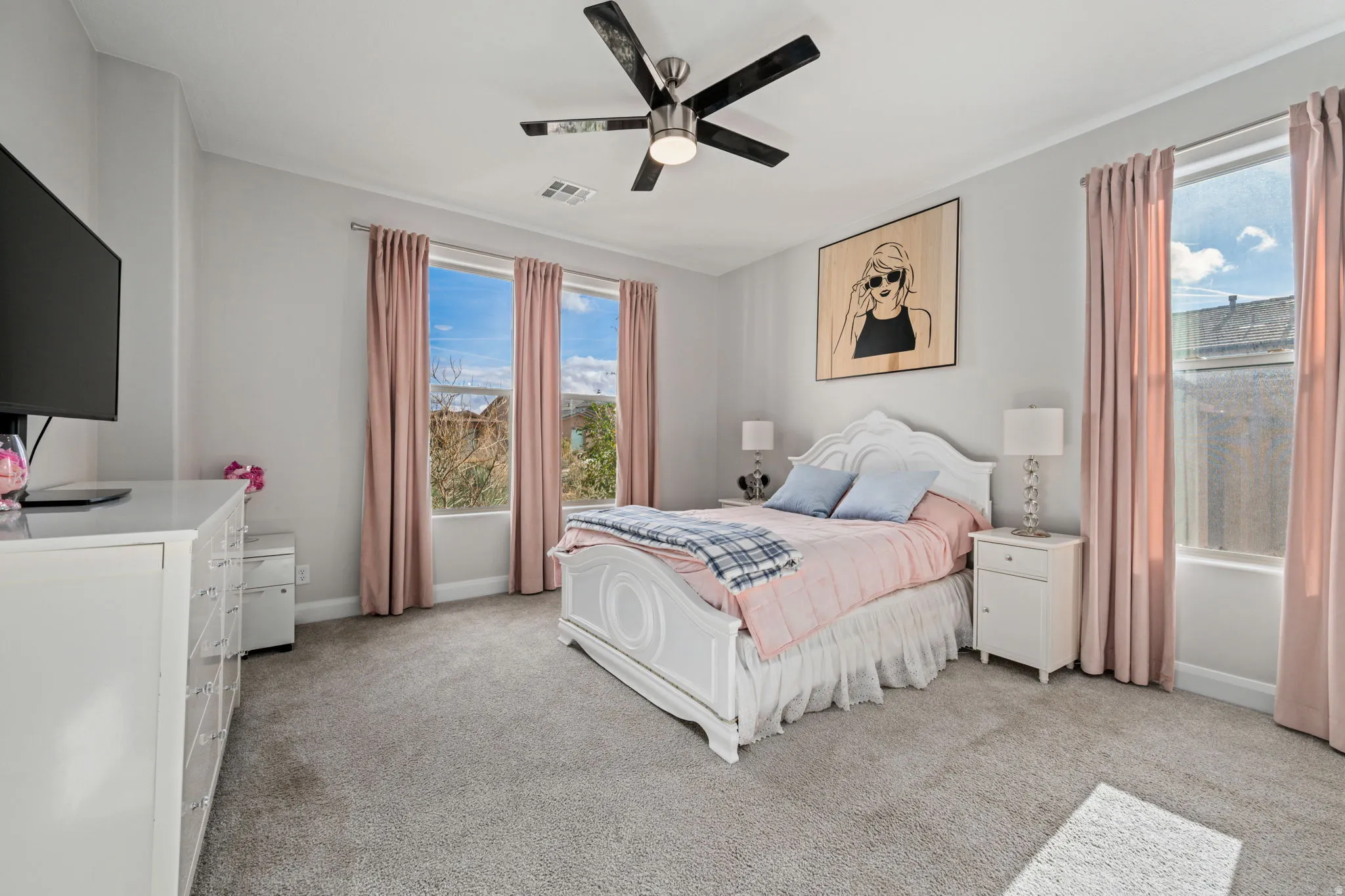 Bedroom with light carpet and a ceiling fan