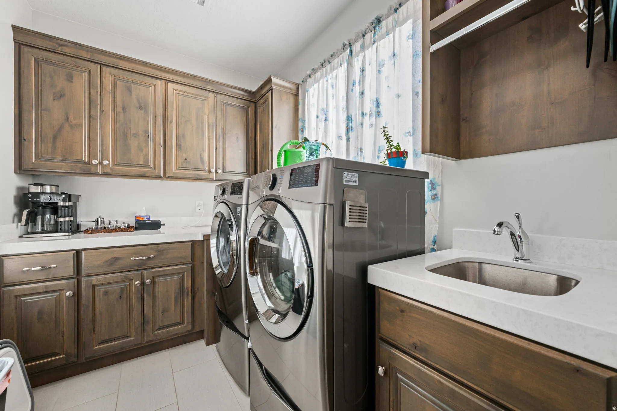 Washroom with washer and clothes dryer, light tile patterned floors, and cabinet space