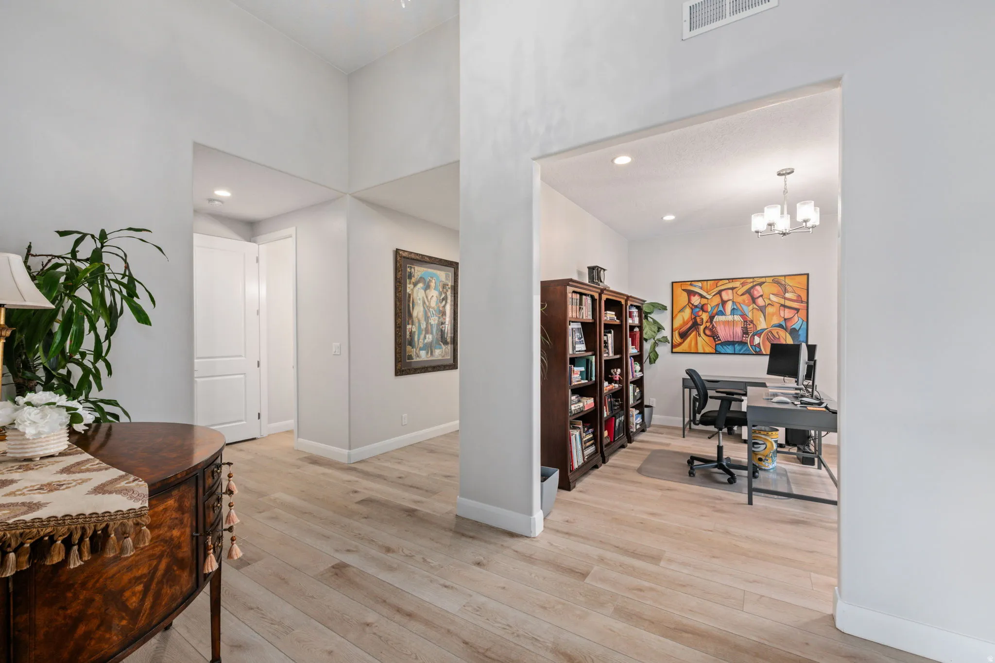 Office area with light wood-style floors, recessed lighting, and a chandelier