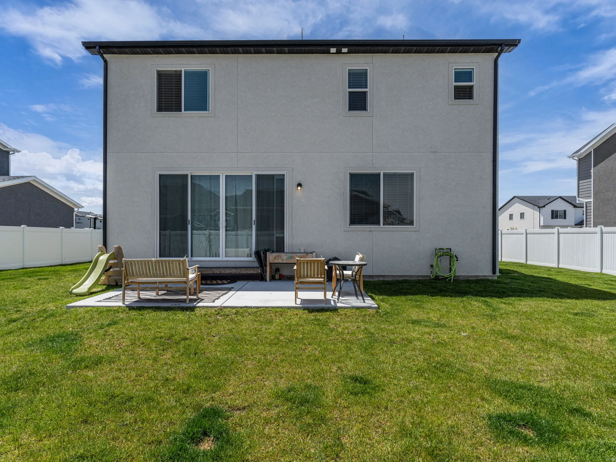 Rear view of house featuring a fenced backyard, a patio, stucco siding, and an outdoor hangout area