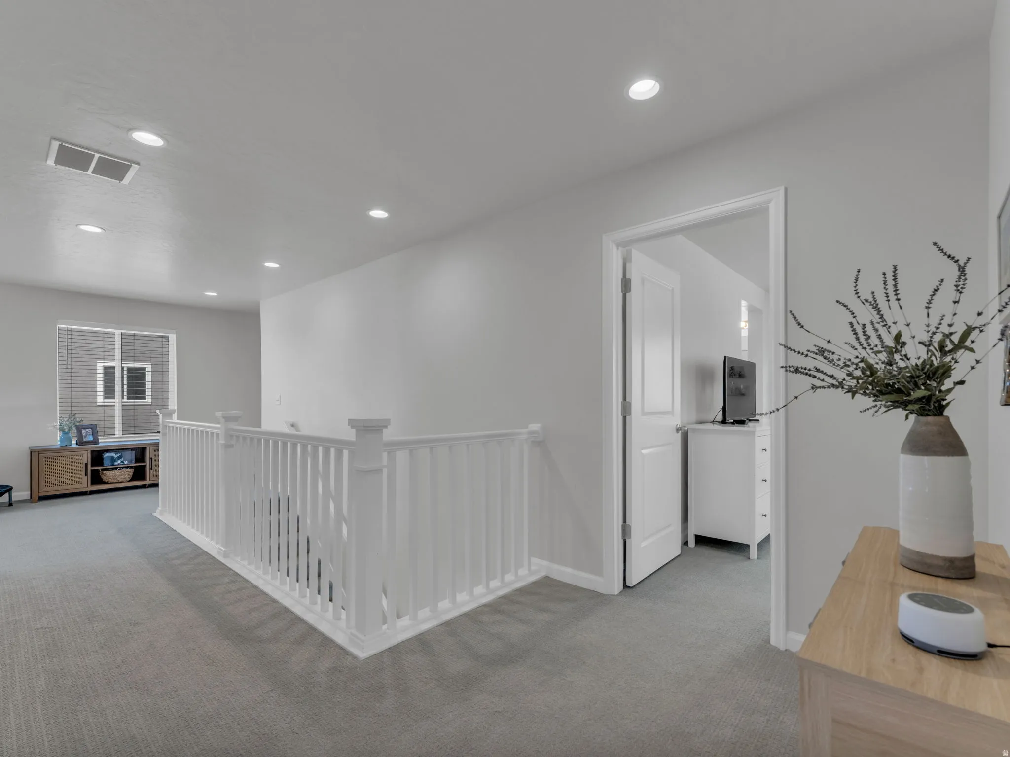 Hall with an upstairs landing, light carpet, and recessed lighting