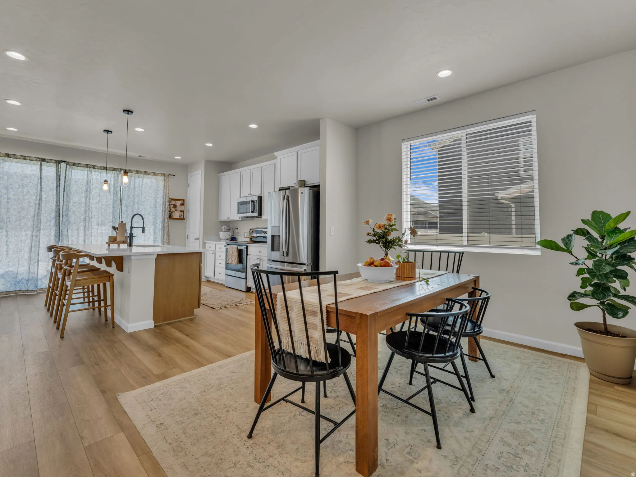Dining space with light wood-type flooring and recessed lighting