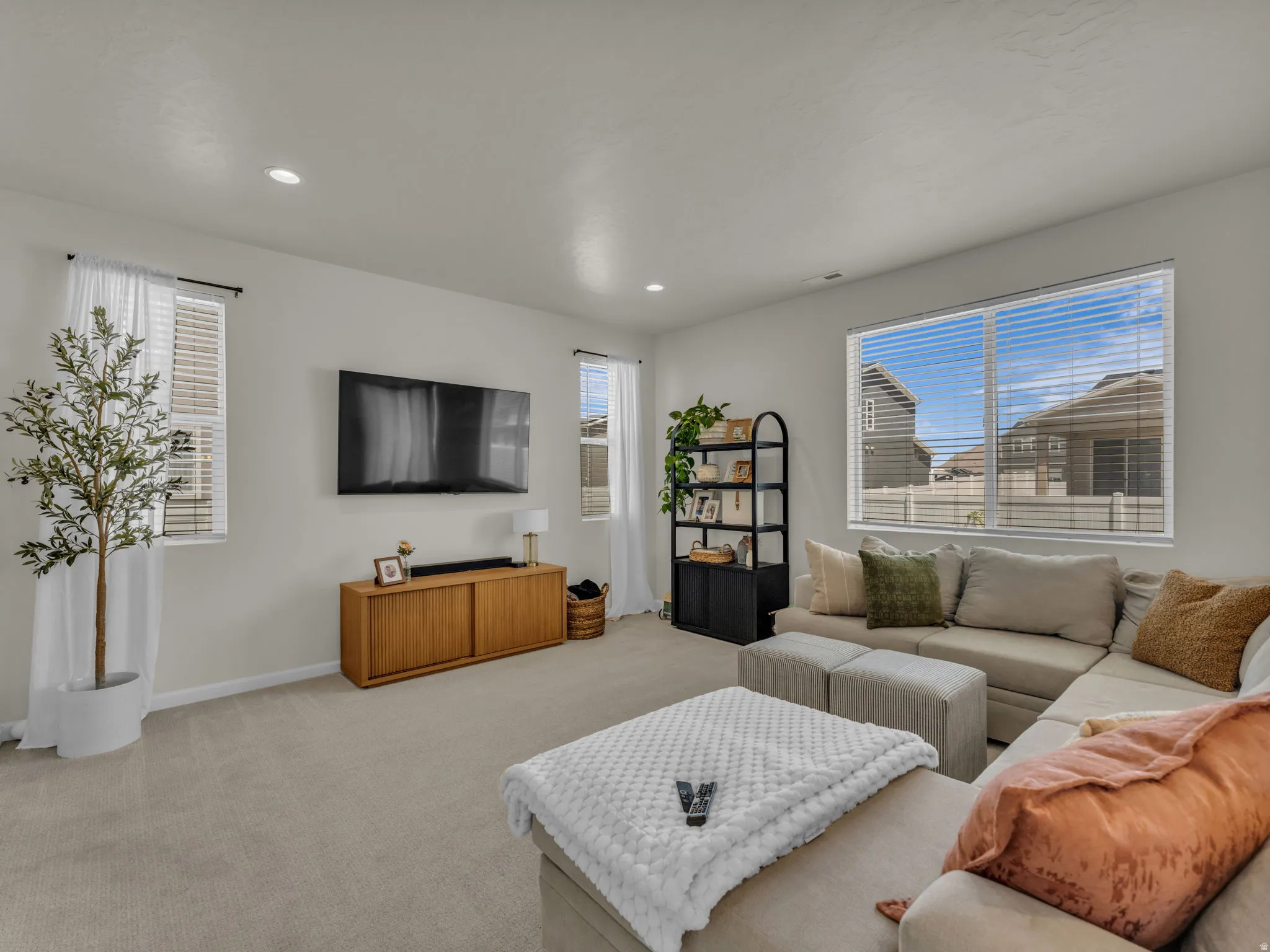 Carpeted living room featuring healthy amount of natural light and recessed lighting