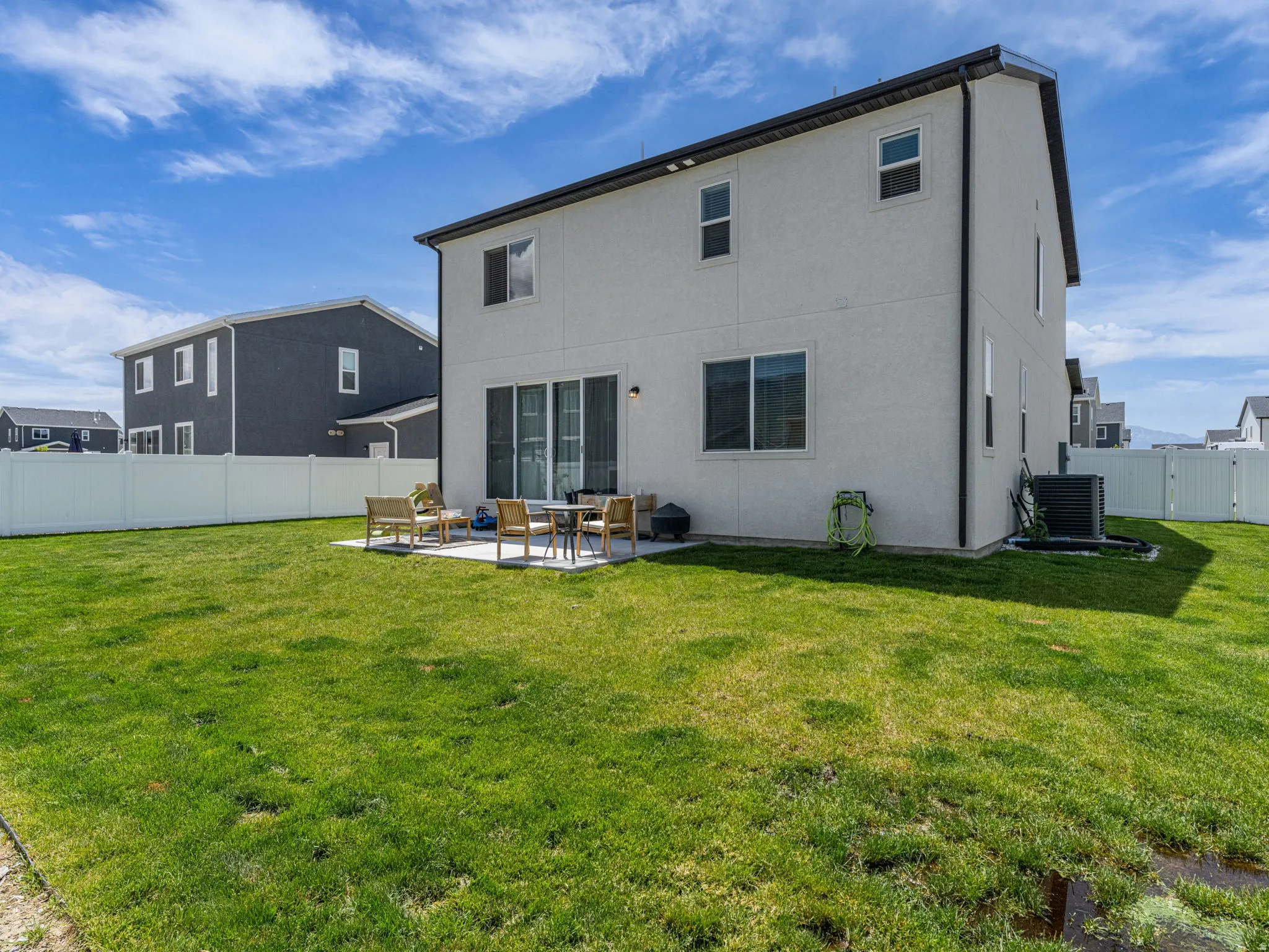 Rear view of property with a fenced backyard, a patio area, and stucco siding