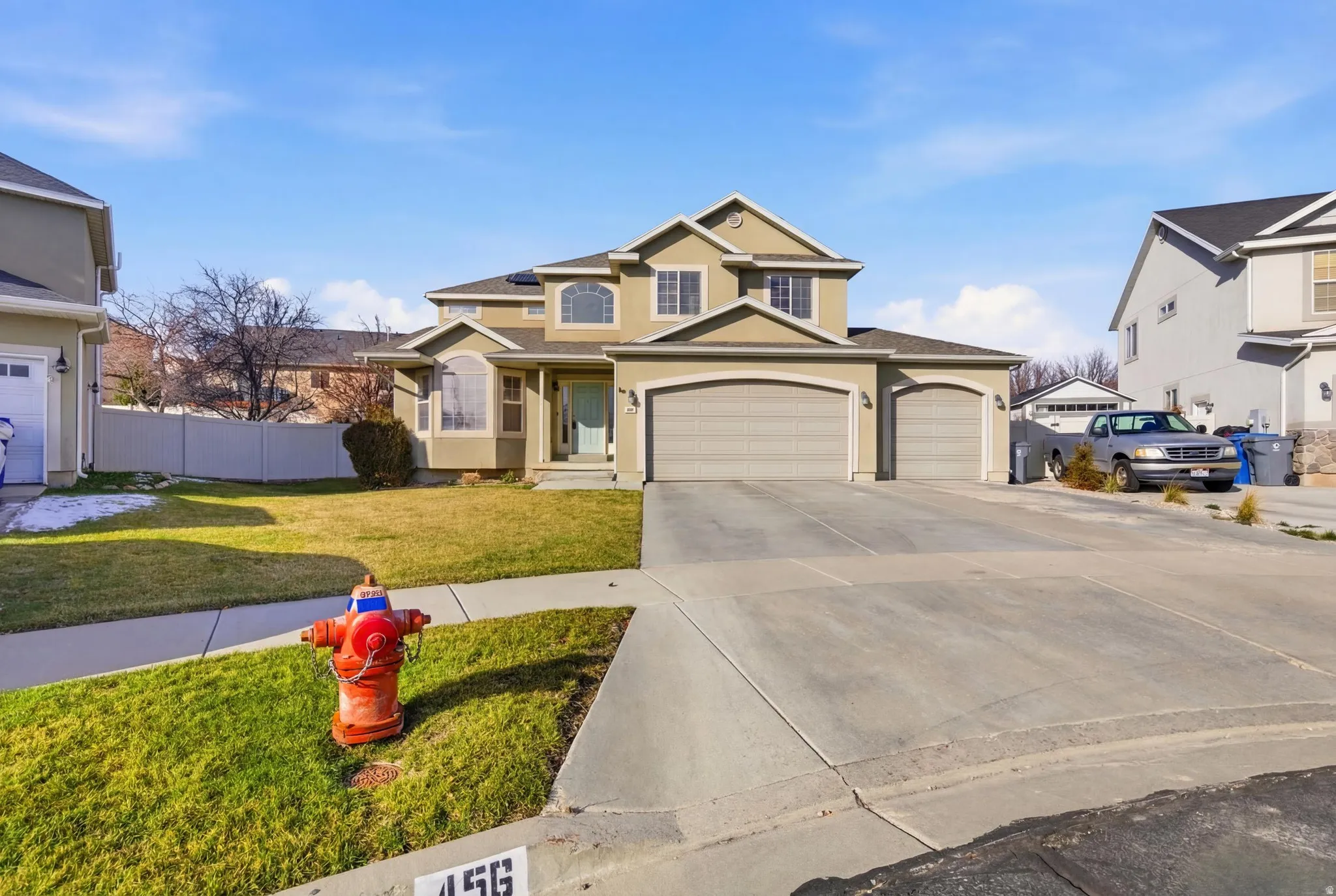Traditional-style house with concrete driveway, stucco siding, and an attached garage