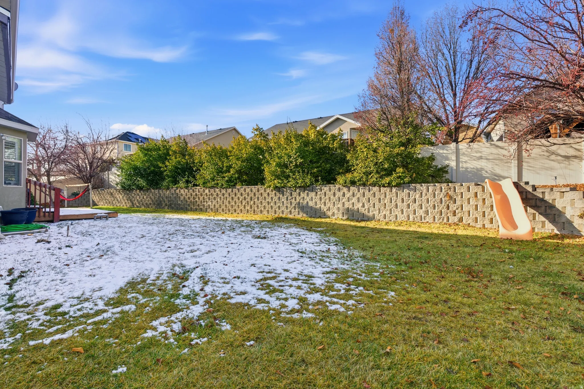 Snowy yard with a fenced backyard and a residential view