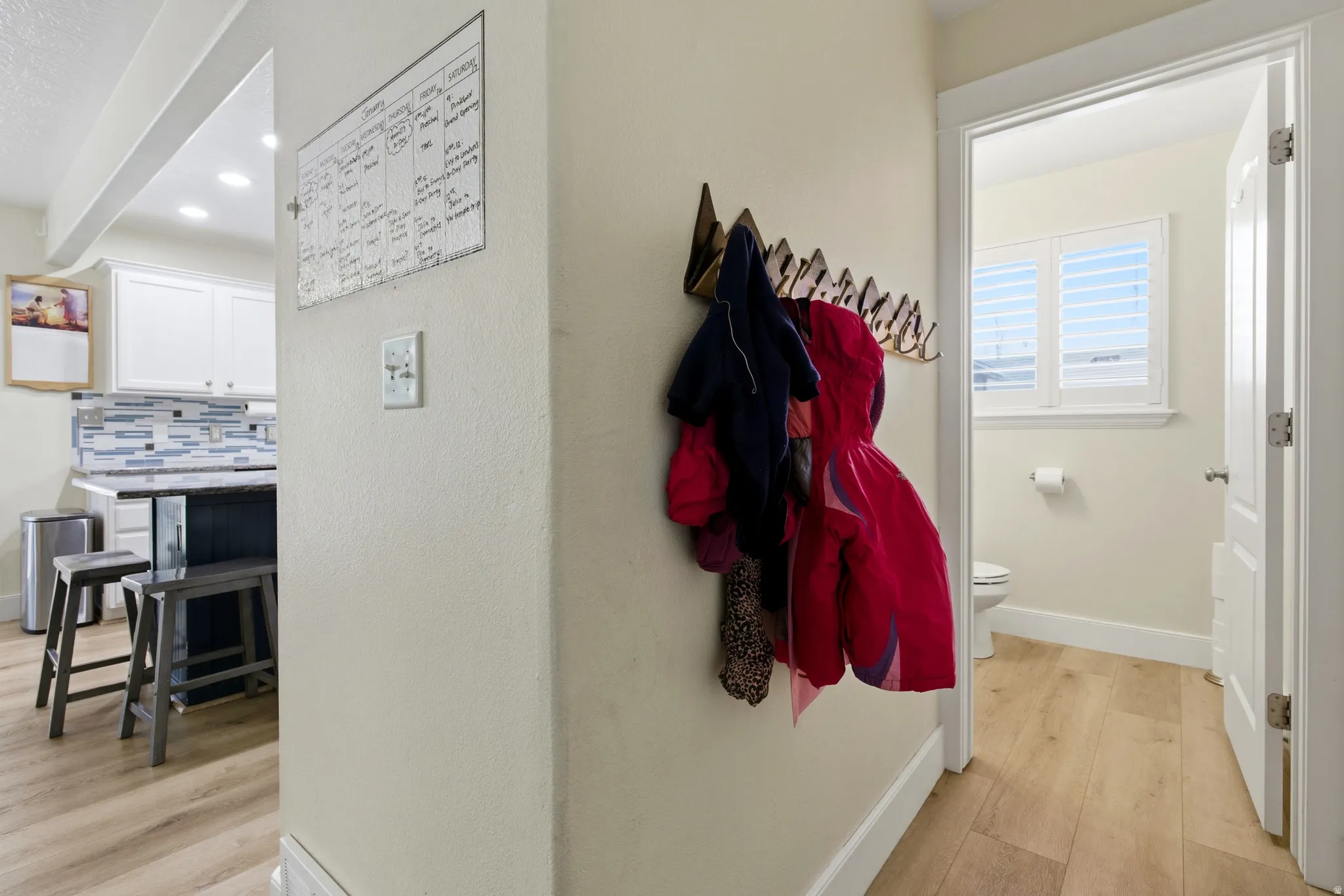 Hallway with light wood finished floors and recessed lighting