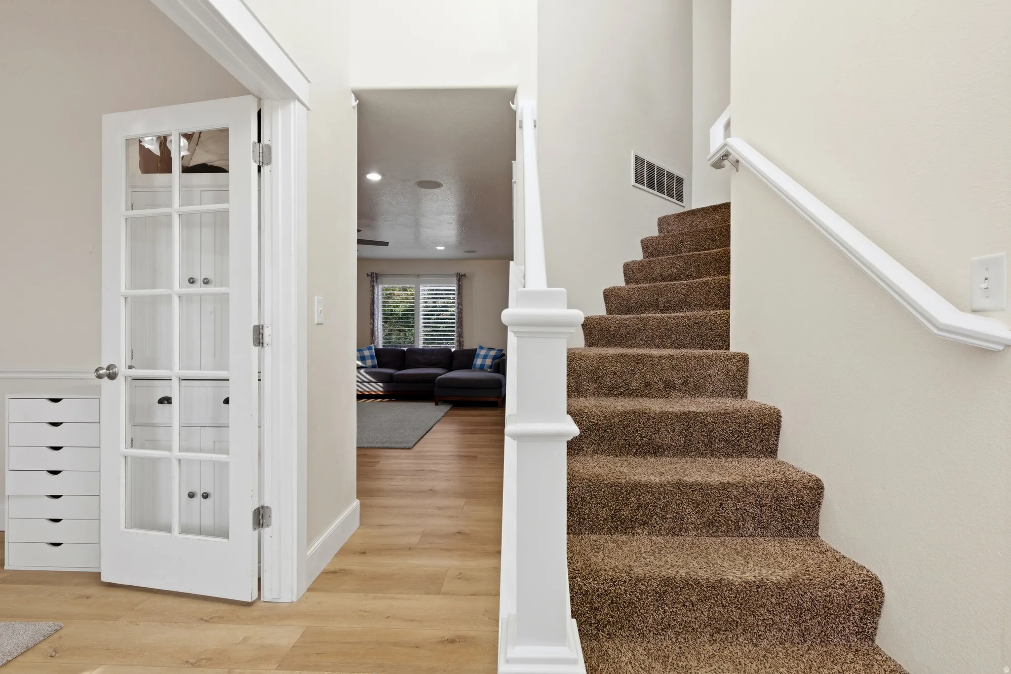 Stairway with wood finished floors and recessed lighting