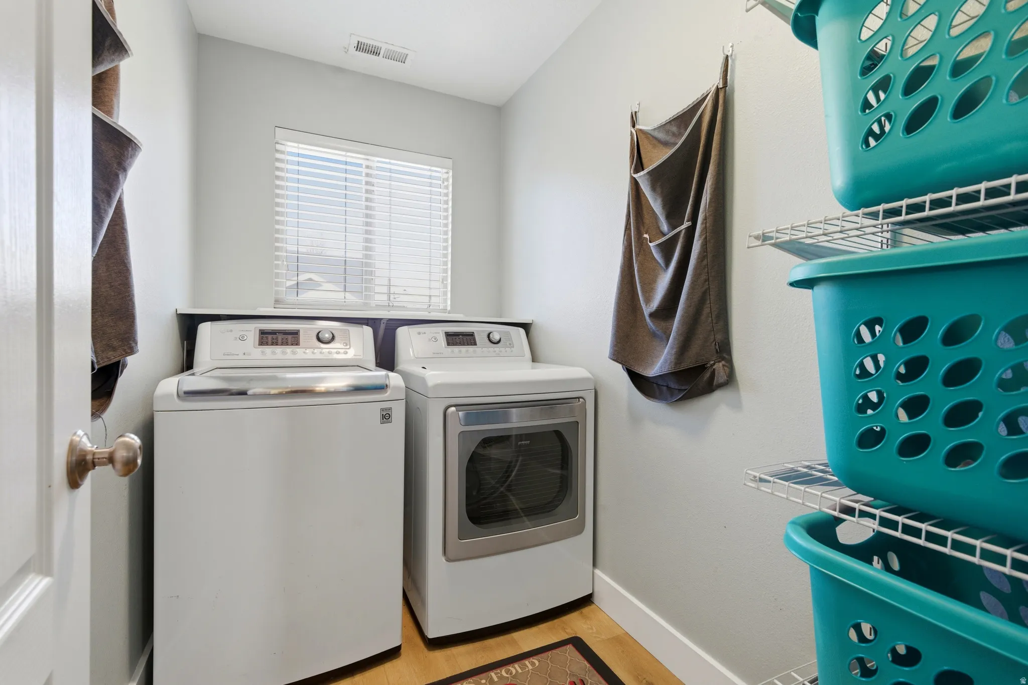 Laundry area featuring light wood-type flooring and washer and dryer