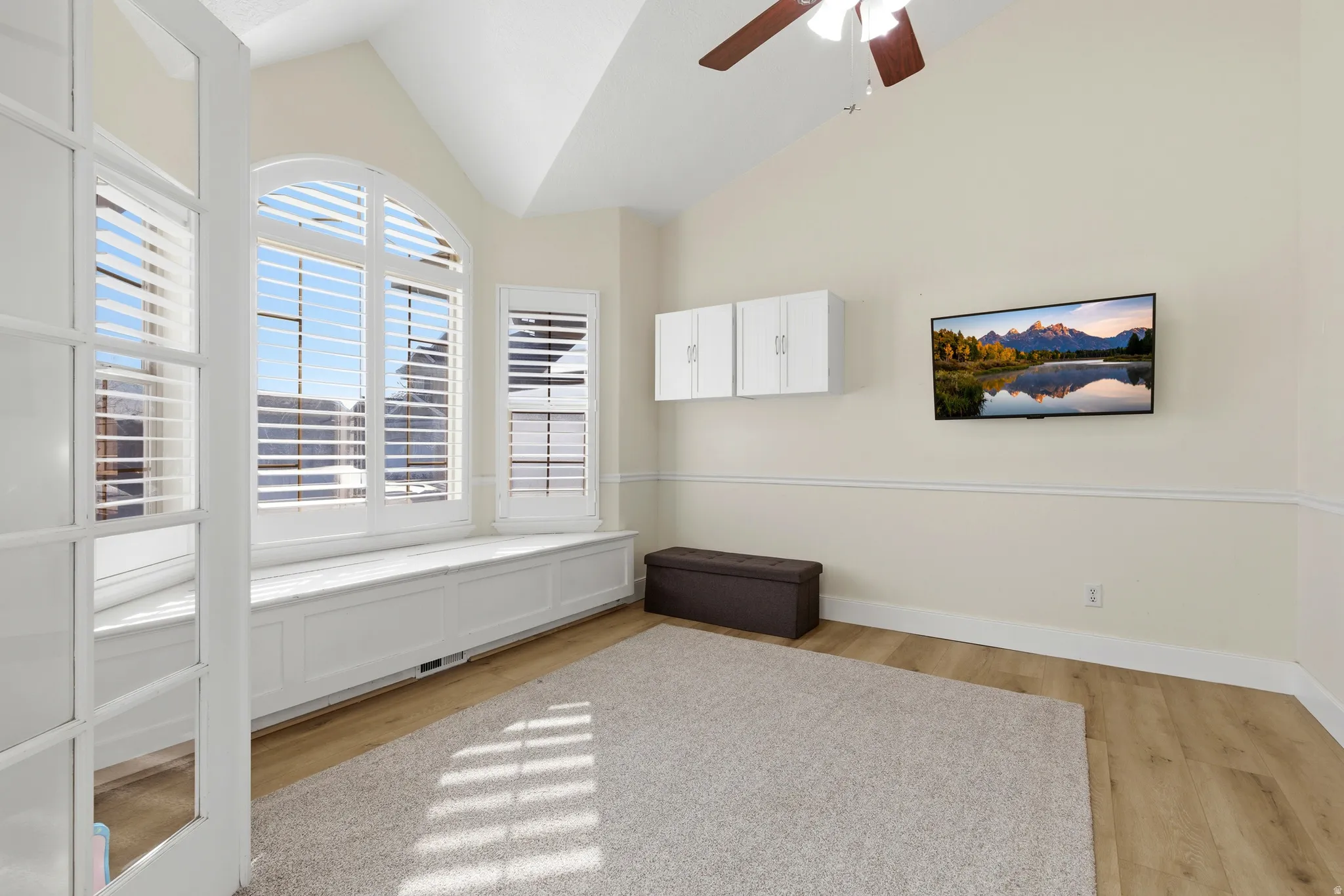 Spare room with light wood-style flooring, ceiling fan, and vaulted ceiling