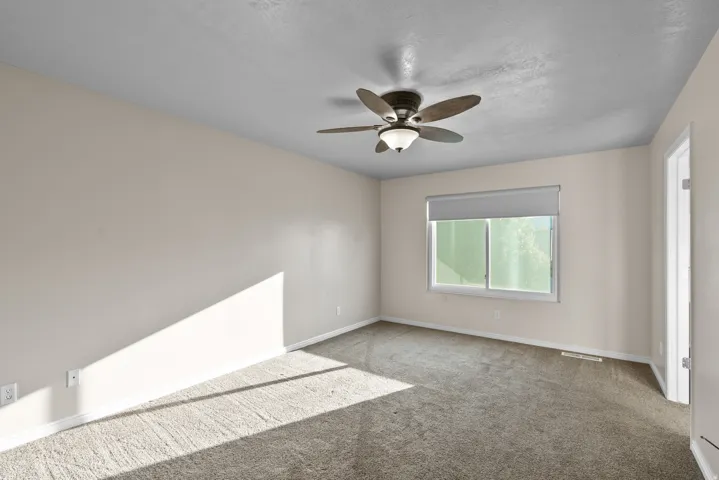 Owners Suite/Master Bedroom Carpeted bedroom featuring a ceiling fan and a textured ceiling
