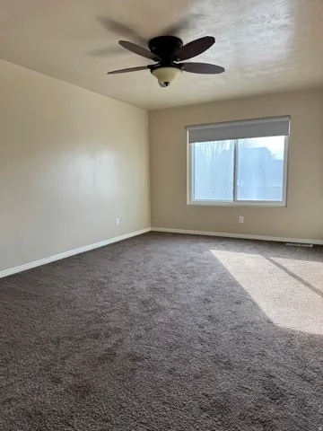 Owners Suite/Master Bedroom featuring dark carpet, a textured ceiling, and a ceiling fan