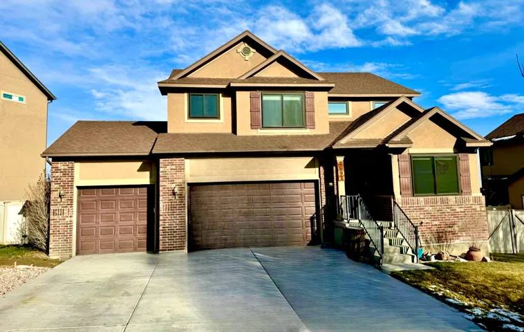 Craftsman-style house with brick siding, concrete driveway, and stucco siding