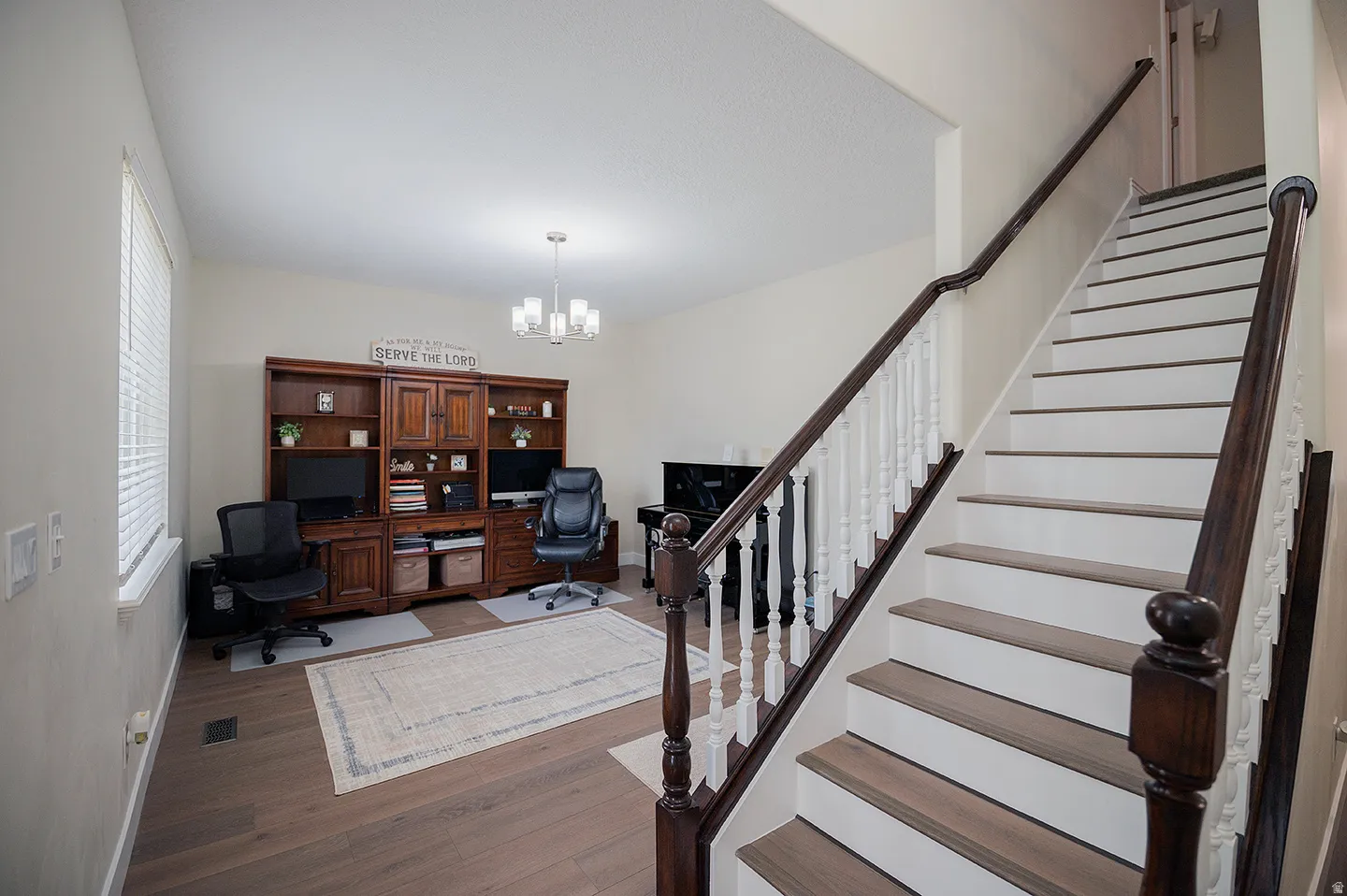 Office space with wood finished floors and a chandelier