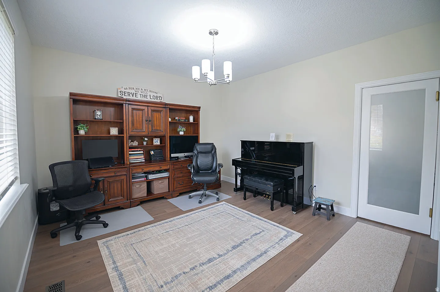 Office space featuring wood finished floors, a chandelier, and a textured ceiling