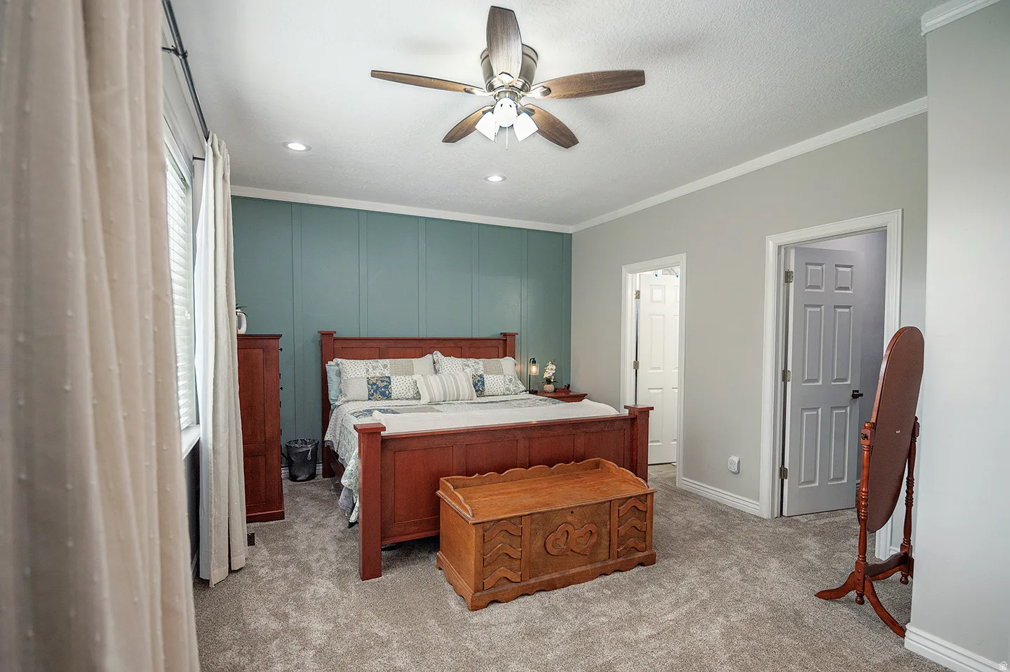 Bedroom with ornamental molding, light colored carpet, ceiling fan, and a textured ceiling