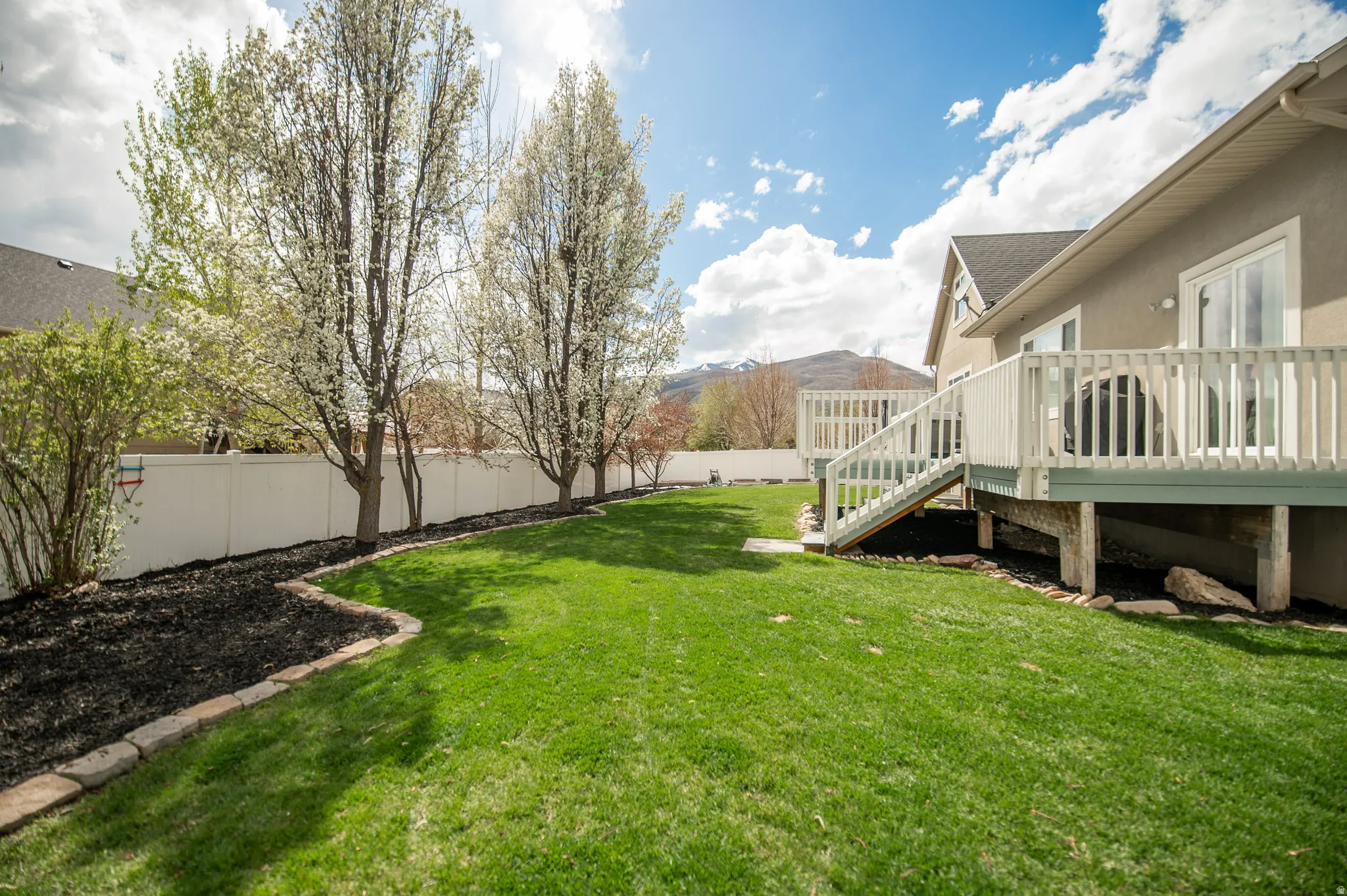Fenced backyard with a deck and stairs