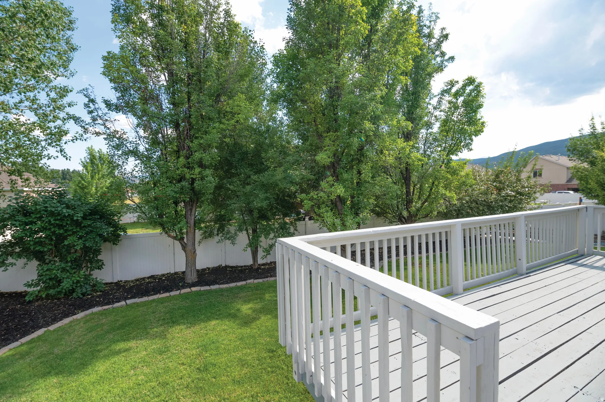 Fenced backyard featuring a wooden deck