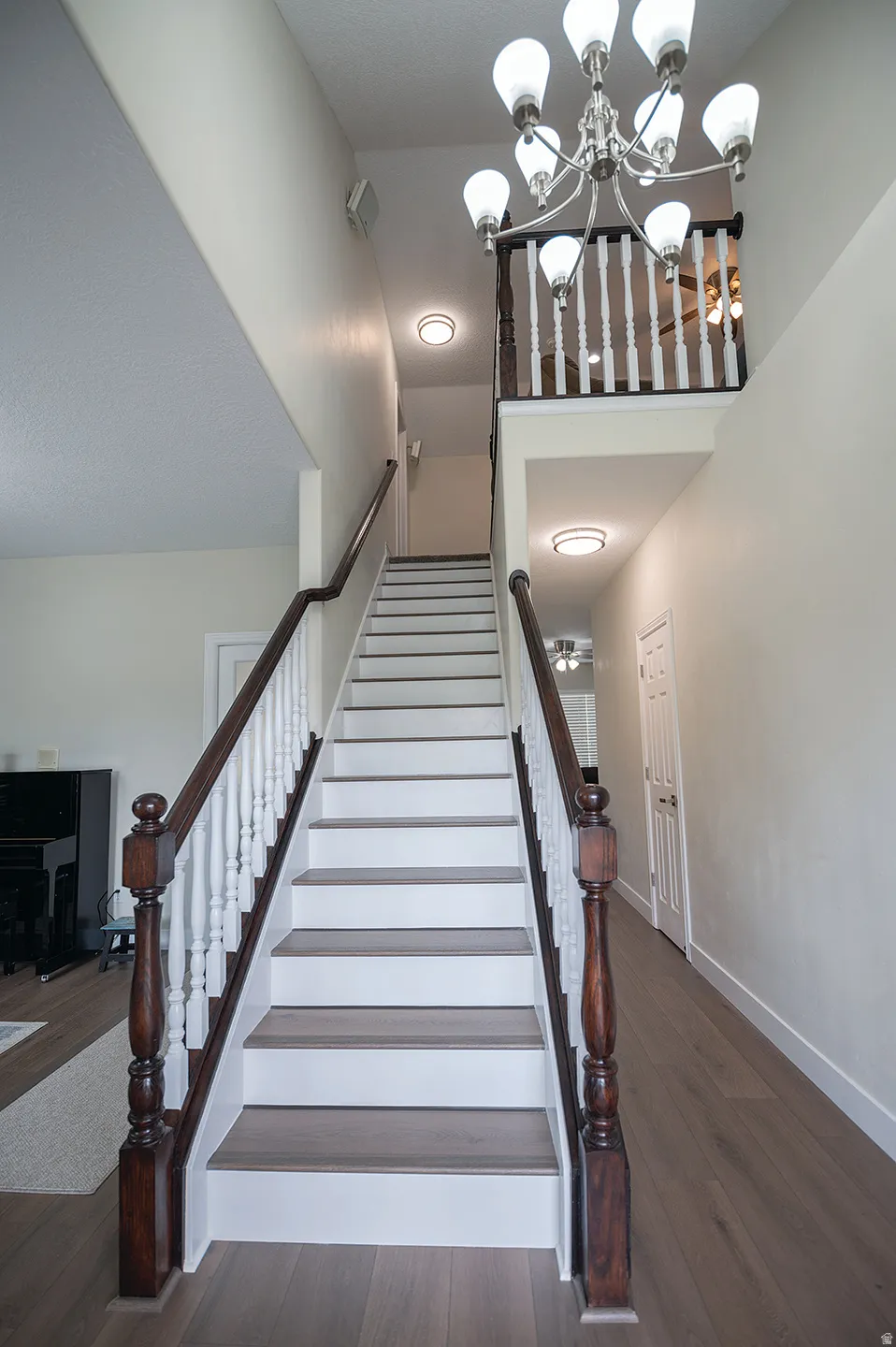 Staircase with a chandelier and wood finished floors