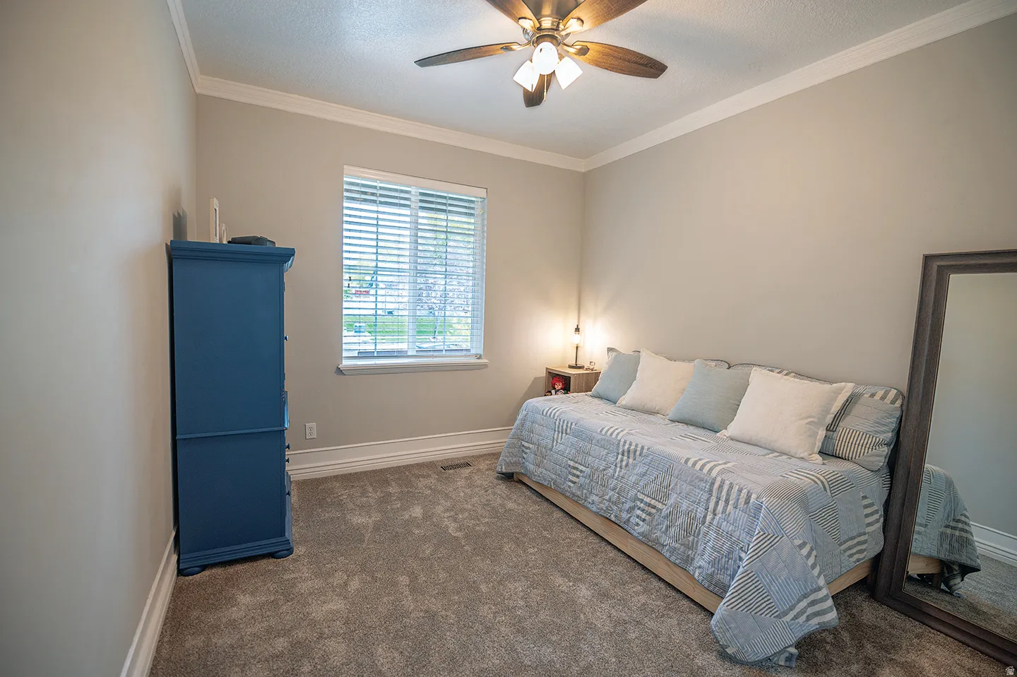 Bedroom with crown molding, carpet flooring, ceiling fan, and a textured ceiling